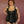 Load image into Gallery viewer, A woman with short hair stands in front of a red wall wearing the Full Curves black leather Ophelia Corset. The corset has straps and garters connected by O-rings as well as O-rings on the sides. There is a metal zipper down the front of the corset.
