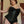 Load image into Gallery viewer, A woman with short brown hair wearing the Full Curves Short Victorian Corset, as well as a black lace bra and underwear, stands in a doorway. The corset is a black leather underbust corset that ends right above the hip. It has garters and a zipper.

