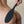 Load image into Gallery viewer, A close-up of a woman’s bare butt and back is shown in front of a white wall. Somebody is holding the black Tantus Gen Mini Silicone Paddle against her butt.
