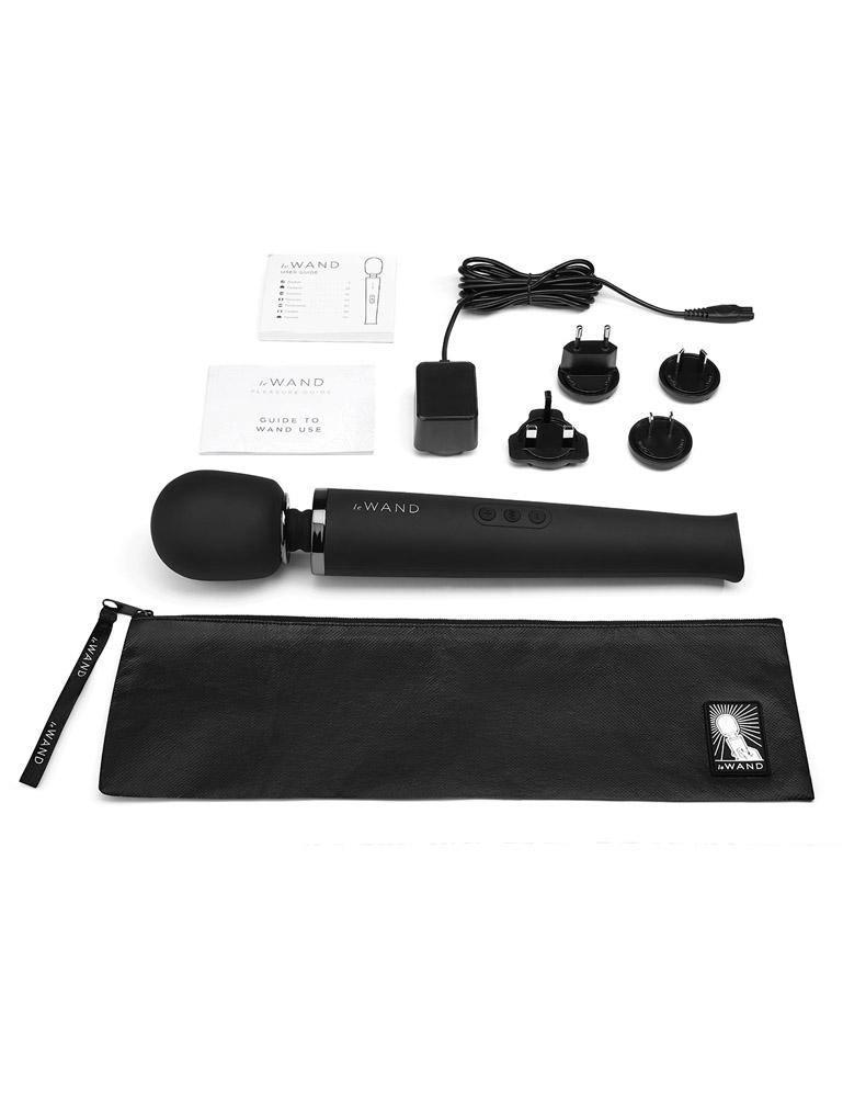 A Le Wand Rechargeable Vibrating Massager in Black is shown against a blank background with the included zipper storage pouch, manual, and power adaptors..