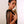 Load image into Gallery viewer, A woman with very short, dark hair poses pressed against a wall. She holds the 24-inch Basic Black Leather Flogger to her chest with the falls draped over her shoulder.
