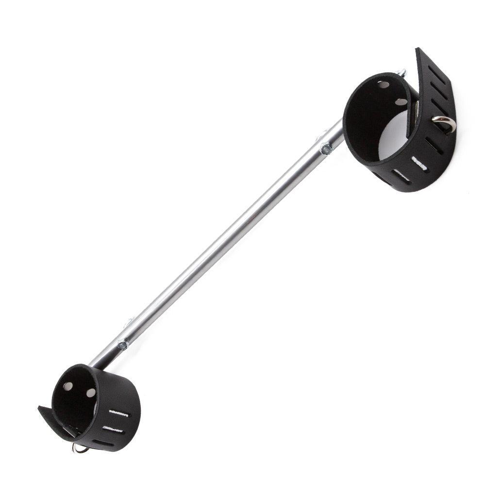 The Chrome Wrist Spreader Bar with Leather Cuffs is shown against a white background. It is made of a chrome rod with black leather wrist cuffs on each end. The cuffs are adjustable and have hasp closures.