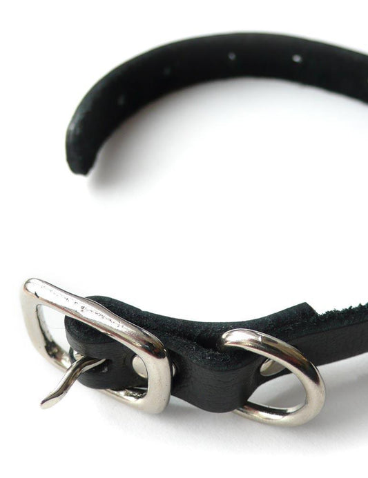 The black leather Buckling Cock Ring with D-Ring is shown unbuckled against a blank background.