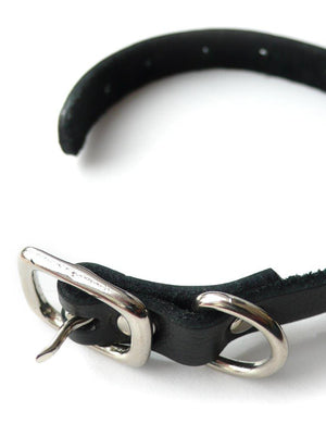 The black leather Buckling Cock Ring with D-Ring is shown unbuckled against a blank background. 