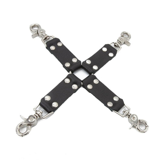 The black Leather Hog Tie is displayed against a blank background. A metal O-ring is in the center with four leather strips attached to it in the shape of an X. Each leather strip has a metal snap hook on the end.
