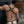 Load image into Gallery viewer, A brunette man wearing the black leather Contender chest Harness and a black thong poses facing away from the camera. The harness forms an X shape on his back with a silver metal O-ring in the center.
