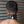 Load image into Gallery viewer, A close-up of the back of a man&#39;s head and neck is shown. He wears the BDSM Alpha Dog Leather Collar with Spikes. The buckle is padlocked shut with a brass padlock.
