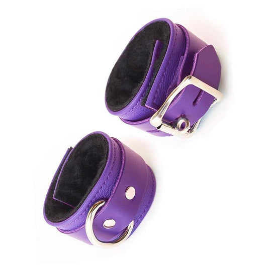 The Purple Fleece Lined Garment Leather Wrist Cuffs are displayed against a blank background. They are made of purple leather with silver hardware, and the interior is lined with fuzzy black fleece.