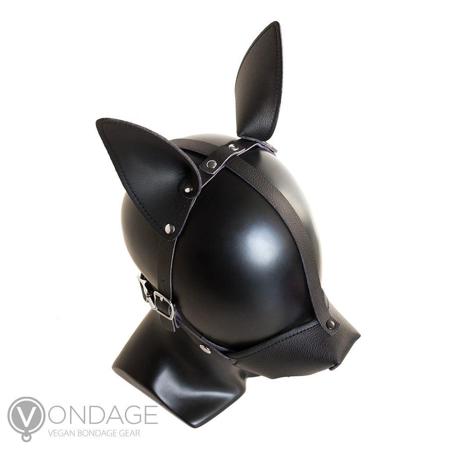 The Vondage Pet Play K9 Muzzle with a Removable Ball Gag is shown on a mannequin head from above. The ears are pointy and attached to a leather strip that runs horizontally across the head. The muzzle buckles near the jaw.
