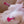 Load image into Gallery viewer, A closeup of a naked woman’s chest is shown. She is using the Kinklab T-Cups Nipple Suction Set with a T-cup suctioning each nipple. The T-Cups are clear with a hot pink twisting mechanism, which have a flower-shaped base.
