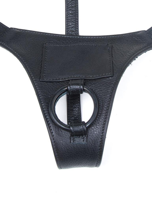 The black leather Buzz Me Tender strap-on harness is shown against a blank background.