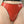 Load image into Gallery viewer, A close-up of a woman&#39;s pelvis is shown in front of a beige background. She wears the red Latex French Cut Panty with black Trim from Syren Latex. The panty has a high rise and rests at the top of her hips, and the leg openings are high-cut.

