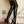 Load image into Gallery viewer, A close-up of a woman&#39;s legs is shown. She wears the black Mila Stockings by Syren Latex, which reach her mid-thigh, and black patent leather high heels.
