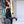Load image into Gallery viewer, A woman with red hair stands in front of a blue ladder with her knee resting on one of the rungs. She wears black Latex Leggings by Syren Latex, a matching top, and black high heels.

