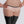 Load image into Gallery viewer, A close-up of a woman&#39;s torso and thighs is shown against a grey back drop. She wears the Chloe Panty by Syren Latex, which is a lowrise boy short style, in baby pink with black trim. She also wears pink latex glovelettes and black latex stockings.
