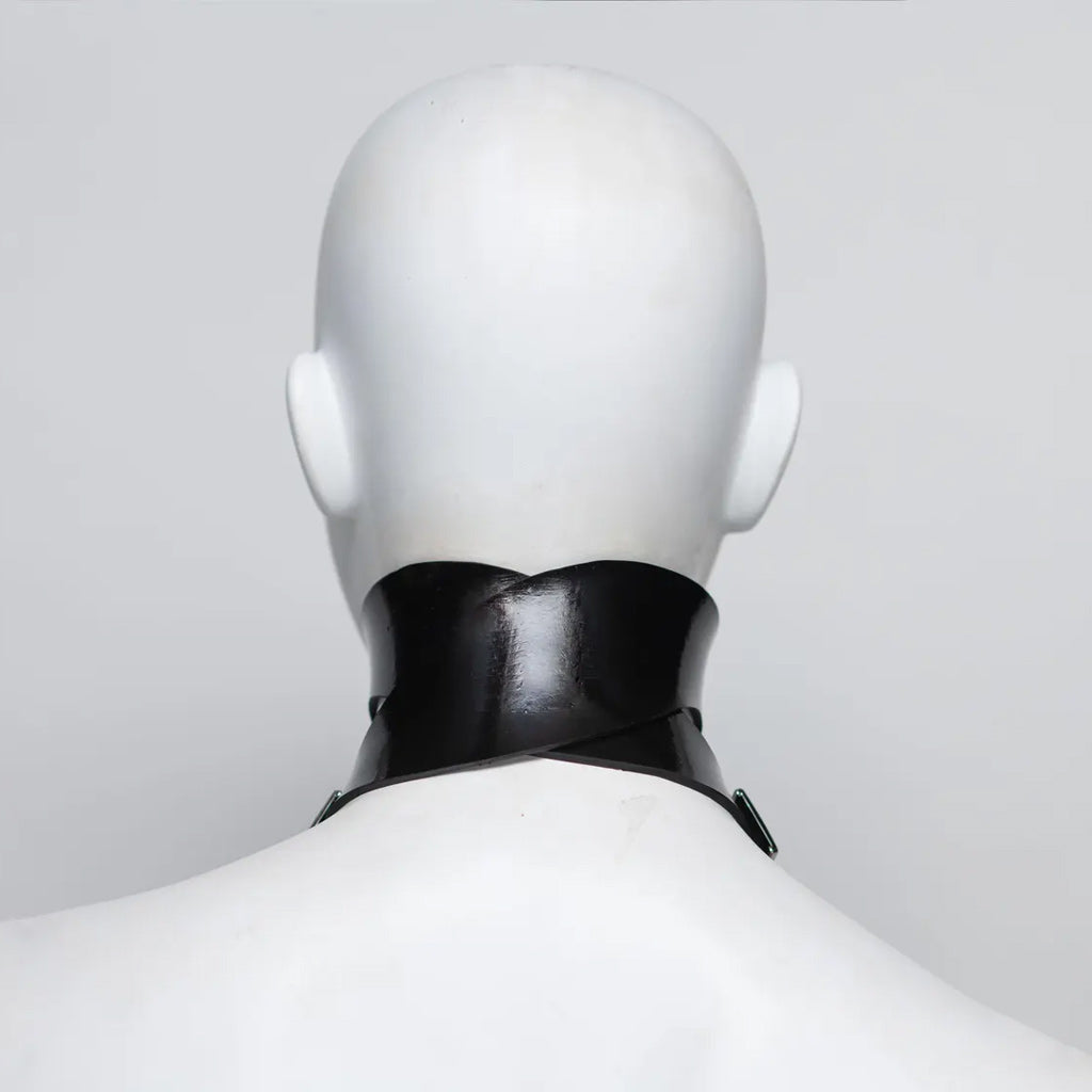 Black rubber choker on a mannequin against a plain background