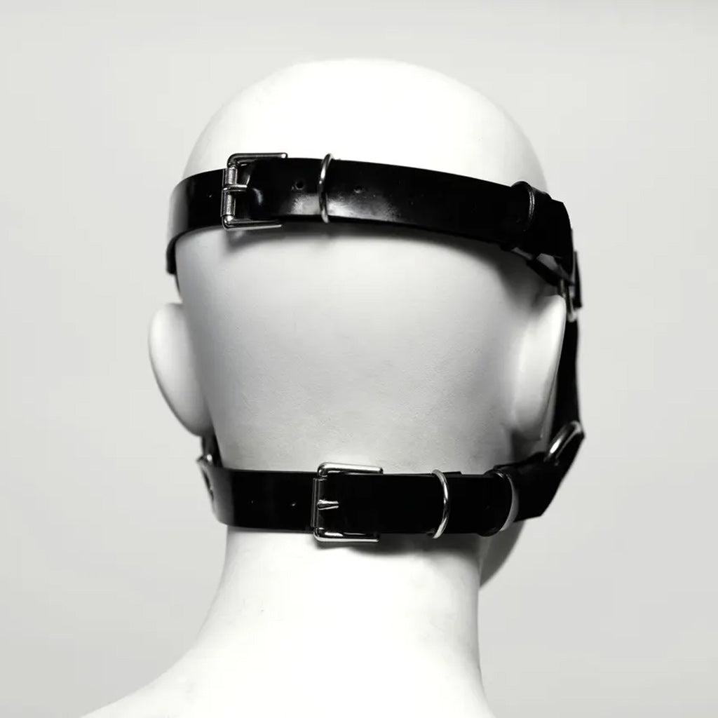 The back view Black rubber head harness on a mannequin head against a white background