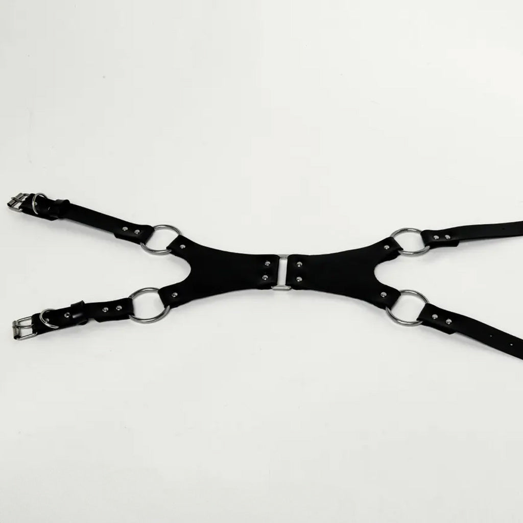 Black Rubber harness laying flat on a white background