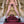 Load image into Gallery viewer, A nude woman stands on a staircase, facing away from the camera and holding the Flicker Whip with both hands behind her back. In front of her sits another nude woman whose wrists and ankles are cuffed to a spreader bar.
