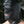 Load image into Gallery viewer, A close-up of a man wearing the black leather Jack the Zipper Bondage Leather Hood is shown. The hood completely covers his face, head, and neck. The hood has nostril holes and zippers over each eye and one over the mouth, which is open.
