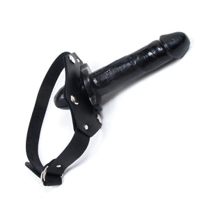 The black In And Out Penis Gag With A Removable Dildo is displayed against a blank background. The gag is made of a black double-ended dildo with black leather straps.