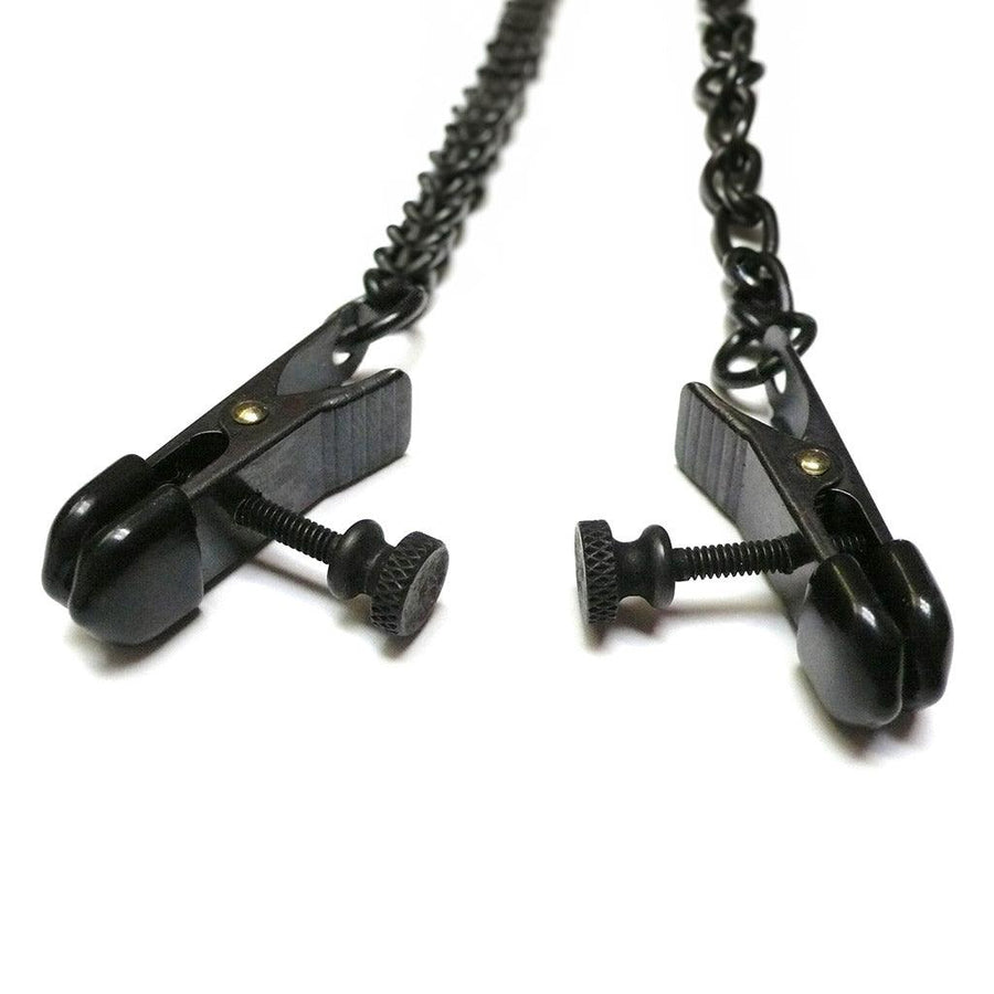 A close-up of the nipple clamps on the purple leather Buckling Collar With Nipple Clamps is displayed against a blank background. The clamps have a screw on the side to adjust the pressure and black rubber tips.
