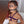 Load image into Gallery viewer, A nude woman with half her head shaved and a purple rope harness tied around her chest sits in a white chair. She wears a black ball gag and the Steel Nose Hook attached to a rawhide lace, which pulls up her nostrils.
