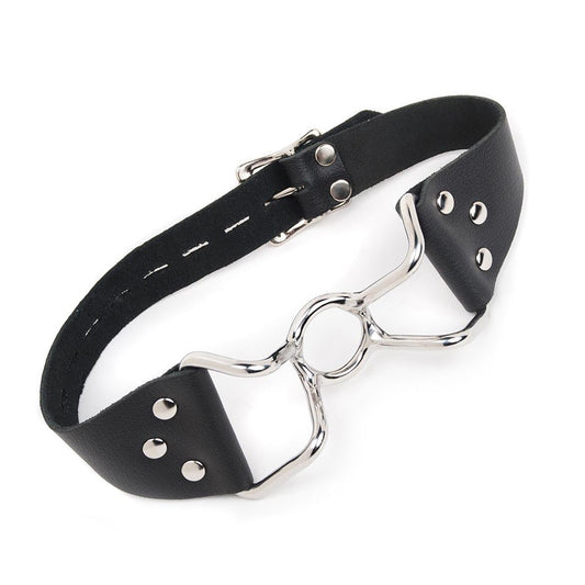 The Spider Gag is shown against a blank background. It is made of a silver metal O-ring in the center with protruding metal handles on each side. A black leather strap connects to the gag's handles. 