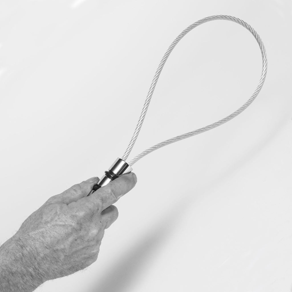Hand holding a metal rug beater against a white background