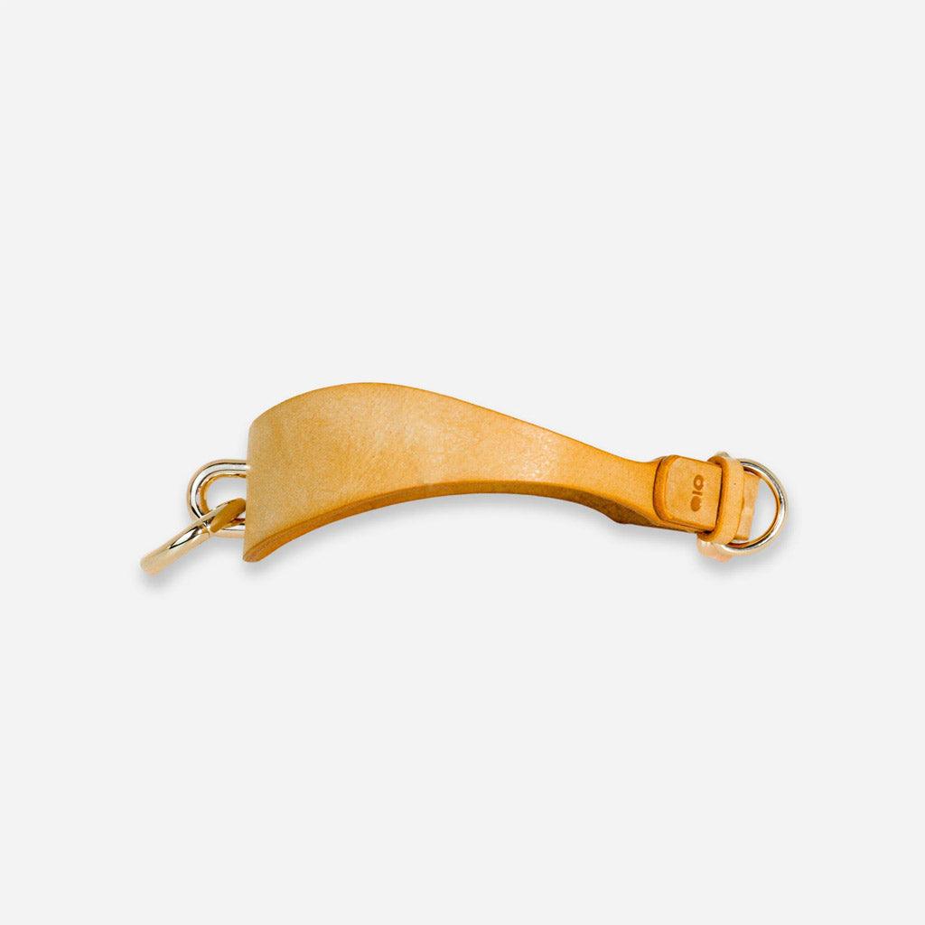The Luxury Leather Day Coller from Neon Coyotes seen from the side on a white background. On the left, the front attachment point, made of gold-colored nickel, is visible in profile. On the right, the adjustable closure is visible with another attachment point. 
