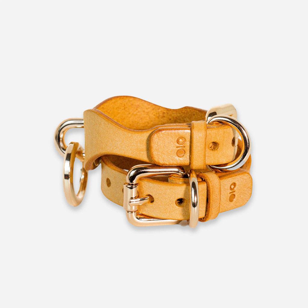 Side view of a pair of BDSM wrist cuffs in bright yellow leather. The angle shows off the adjustable fastening point.