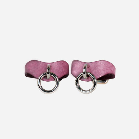 Two BDSM wrist cuffs made of lavender leather from a front view. In the center is a silver nickel-plated attachment point.
