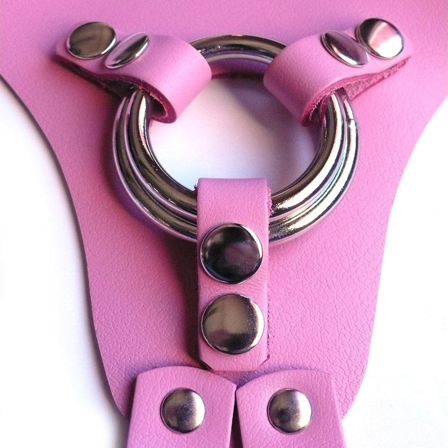 A close-up of the center of the pink leather La Strap On harness, showing the two different-sized silver metal O-rings that it comes with.
