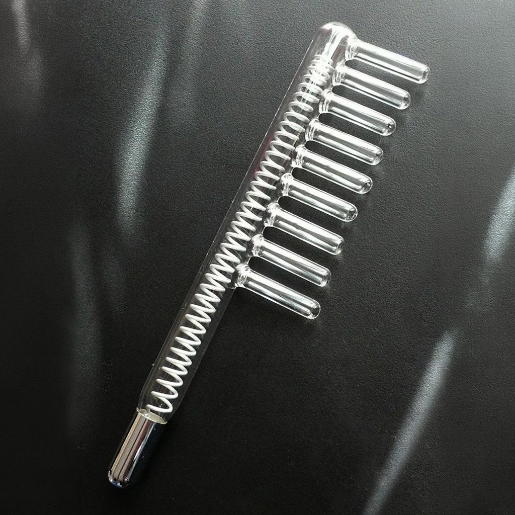 The comb electrode with coil attachment is shown on a black leather background.