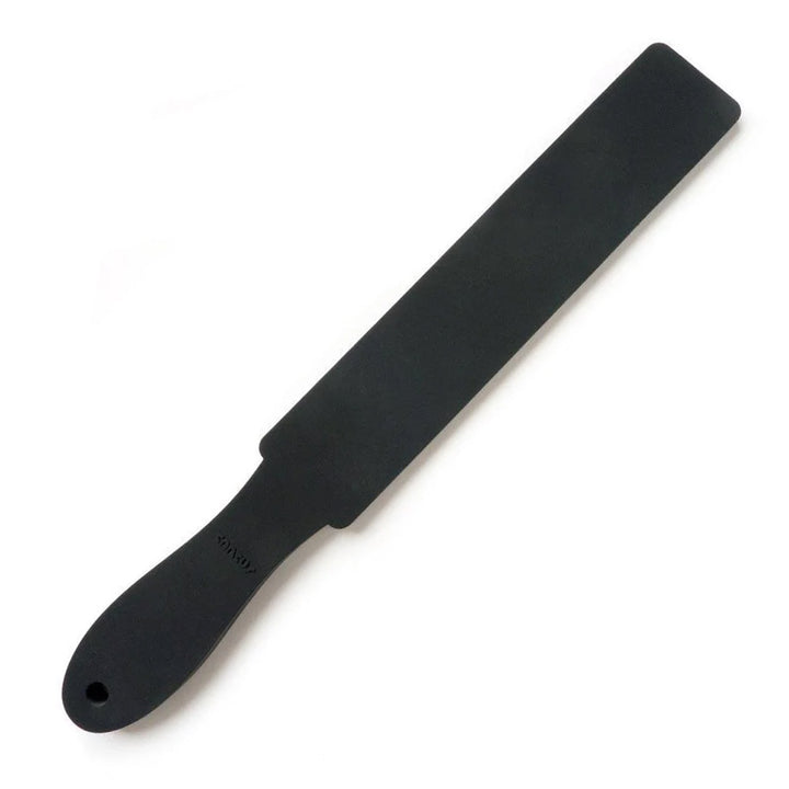 The Wham Bam Tantus Paddle is displayed against a blank background. The paddle is made of matte black silicone and has a narrow, rectangular impact point with a handle with a rounded end. 