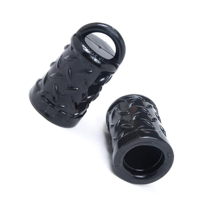 A pair of black rubber Gripper Nipple Suction cups are displayed against a blank background. They are half-cylinder shaped and are hollow with a small loop at the top.