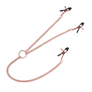 The pink Entice Triple Intimate Clamps are displayed against a blank background. There is a rose-gold chain shaped like a Y with an adjustable clothespin-style clamp with black rubber tips at each end.