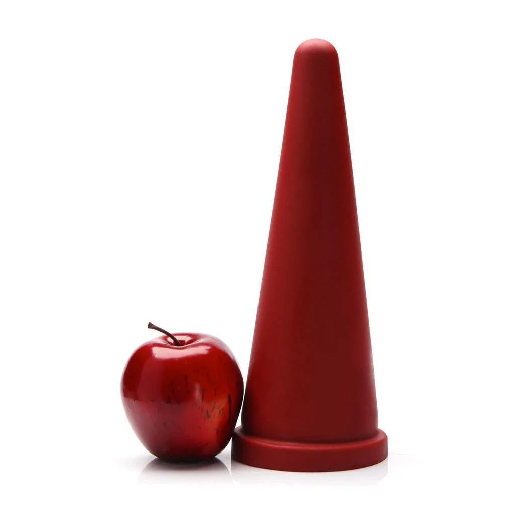 The red Tantus Cone XL Silicone Anal Trainer is shown next to a red apple in front of a white background. 