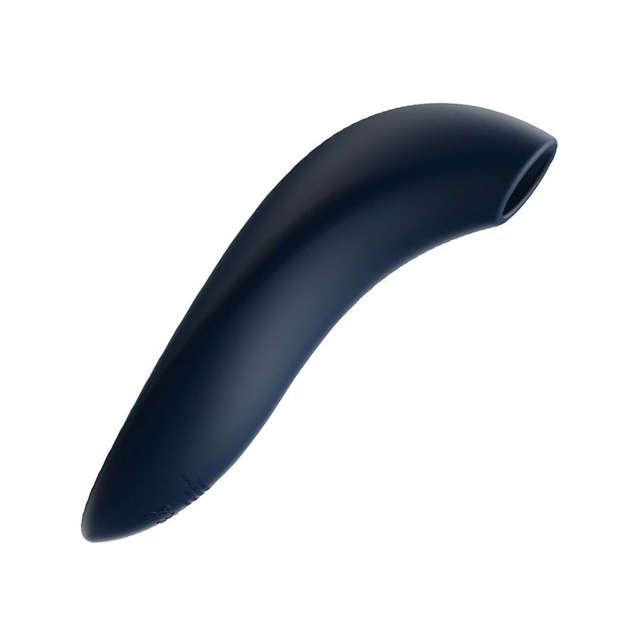 The We-Vibe Melt Pleasure Air Clitoral Vibrator in Midnight Blue is shown from the side against a blank background. The toy has a straight handle a sligtly curved top, where there is a hole.