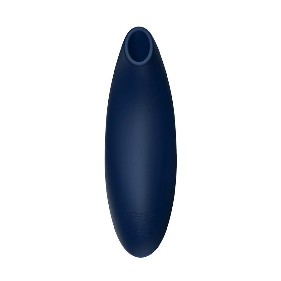  The We-Vibe Melt Pleasure Air Clitoral Vibrator in Midnight Blue is shown next to a cell phone against a blank background. The cell phone screen shows the app that can be used to control the toy.