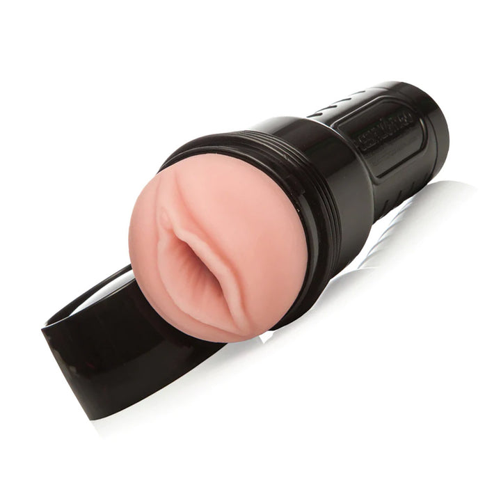 The Fleshlight Go Surge Masturbator is shown uncapped against a blank background with. The Fleshlight is light pink and modeled after a realistic vagina, and the case is black.