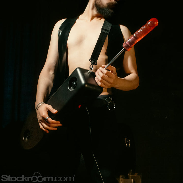 The torso of a bearded man, barechested, holding the Shredder Fuck Machine across his chest like a guitar. 