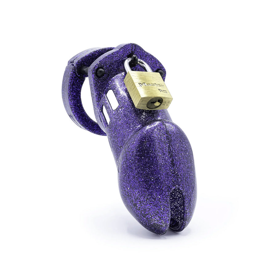 A chastity cage made of purple glitttery plastic, with a brass padlock on the top. 