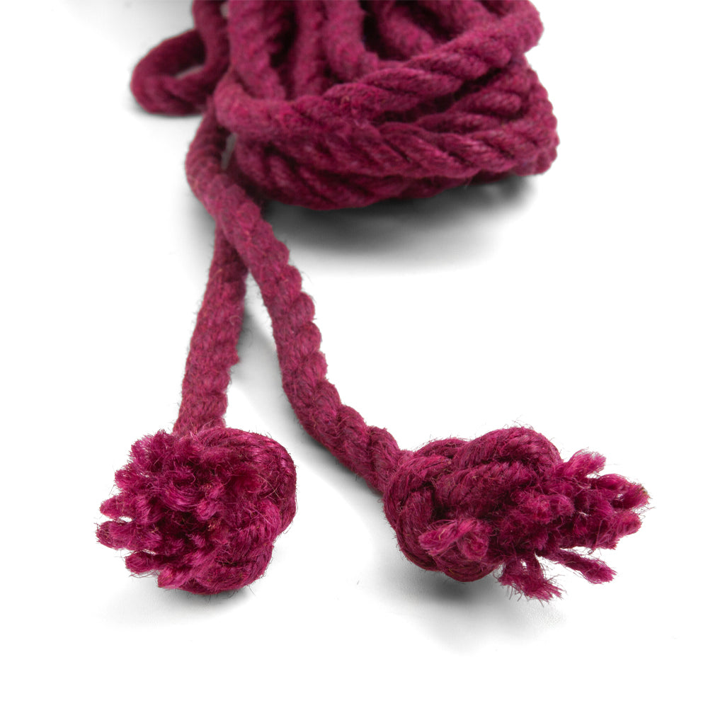 The knotted ends of the wine colored jute waxed rope are shown on a white background. 