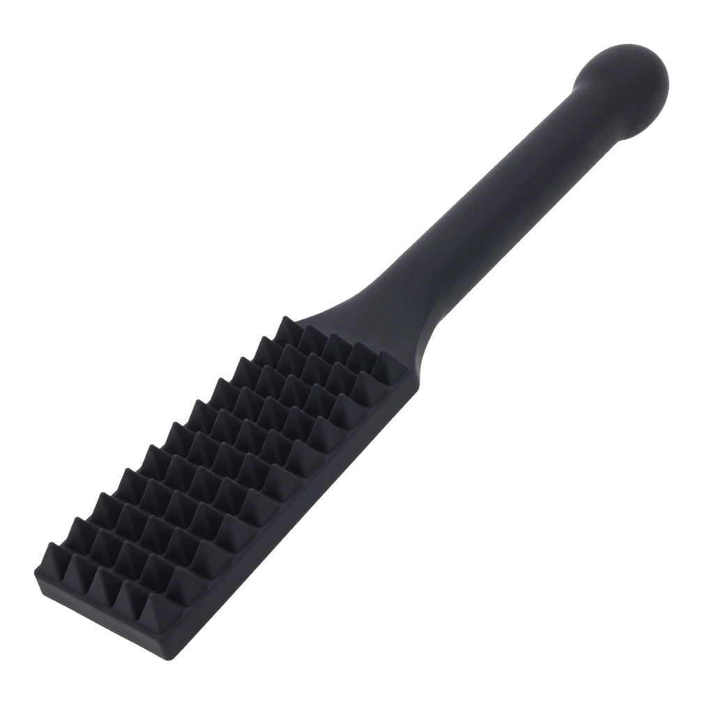 Black silicone paddle with pyramid studs with a handle on a white background