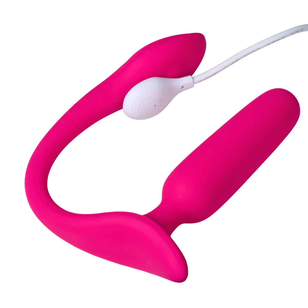 The Lovense Lush anal dual vibrator is shown connected to it's charger on a white background