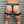 Load image into Gallery viewer, A close-up of a man&#39;s body from his waist to his knees is shown in front of a metal wall. He faces away from the camera and wears black leather underwear and Leather Thigh Cuffs, which are padlocked in the back.
