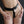 Load image into Gallery viewer, A close-up of a woman&#39;s hips is shown in front of a black background. She is wearing the black leather Strap-in Chastity Harness, which has a waist band with an attached leather strip that runs between her legs. The belt is padlocked in the front.
