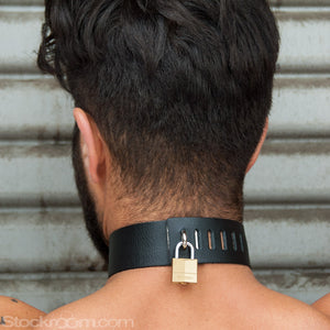 A close-up of the back of a brunette man’s neck is shown. He wears the Locking Leather Collar, which is locked shut with a brass padlock.