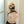 Load image into Gallery viewer, A topless blonde woman is shown from the chest up with a black leather gag covering her mouth. Her arms are pulled behind her back by the Stockroom black leather Arm Binder. The straps for the arm binder cross over her chest in an X.
